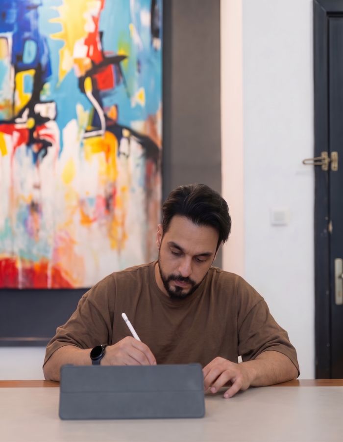 حاتم الخطيب يعمل على جهاز لوحي بأقلم رقمي